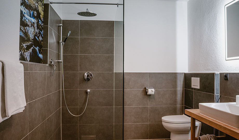 Alpenzeit Ferienhaus "Herzstück" Badezimmer mit Dusche, Becken, WC